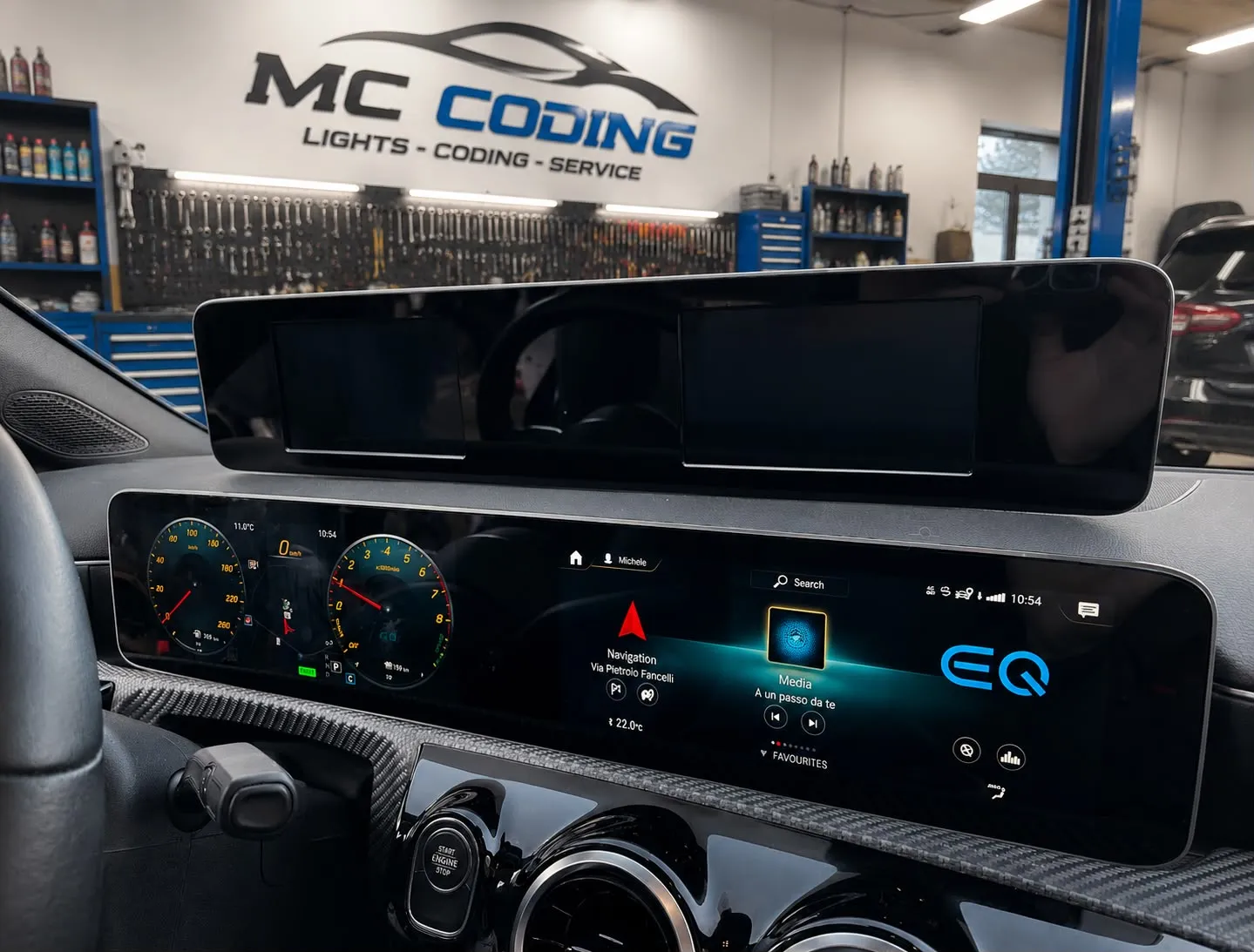 Plancia Mercedes-Benz W177 con i display MBUX da 10+10 pollici installati e accesi, e il vecchio pannello 7+7 pollici smontato appoggiato sopra la plancia