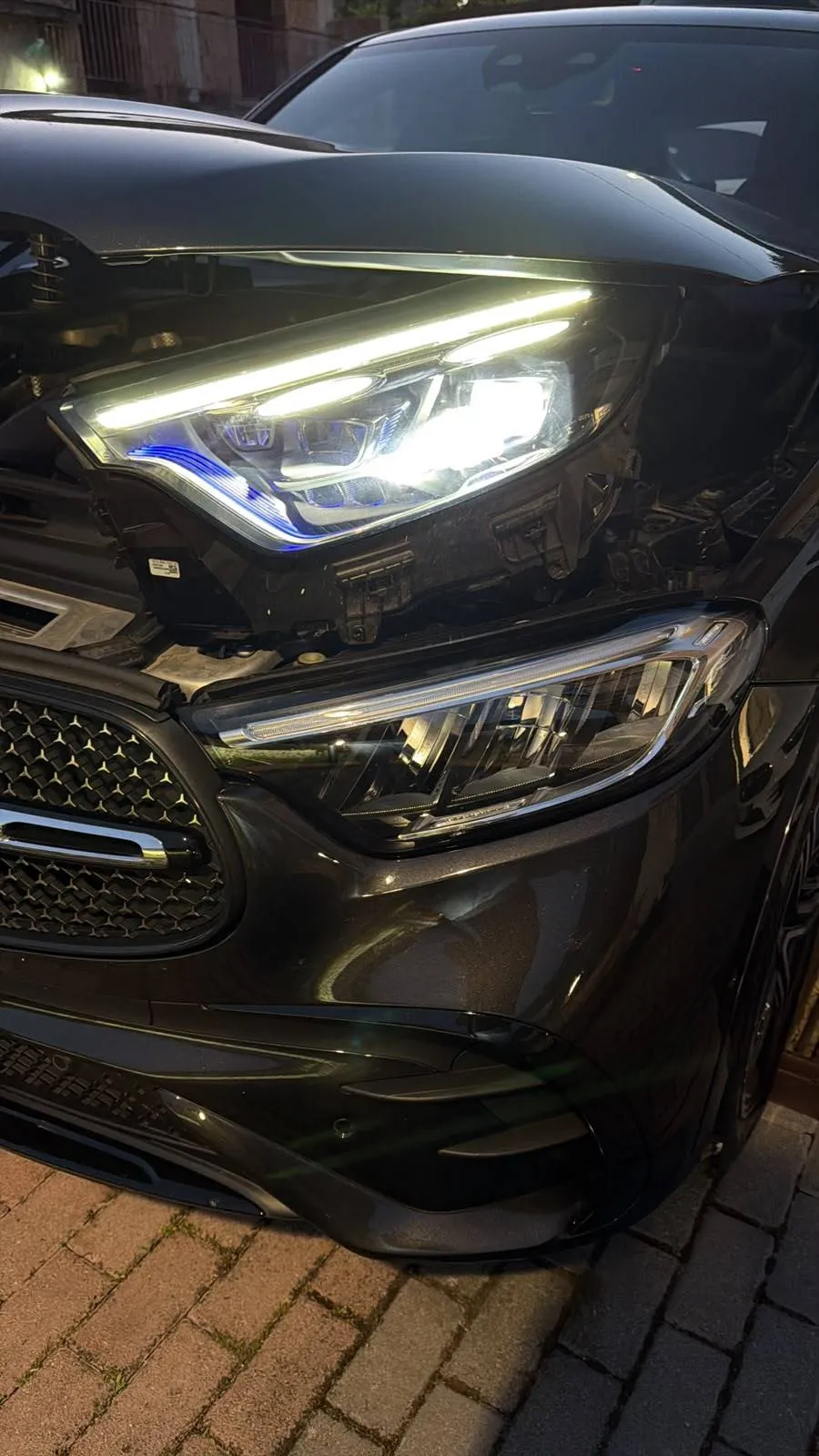 Faro DIGITAL LIGHT acceso, con firma luminosa e accento blu, appoggiato sopra il faro Full LED ancora montato sulla Mercedes-Benz GLC X254